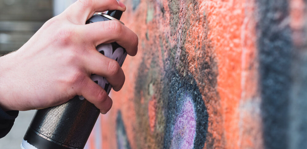 man-s-hand-drawing-graffiti-wall-with-aerosol-can